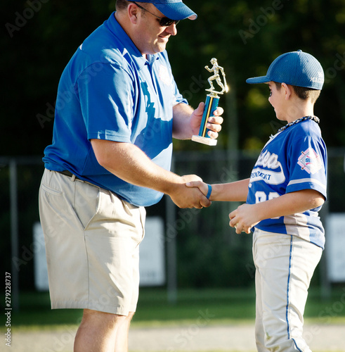Photography Coach presenting trophy to little league player (8-9)