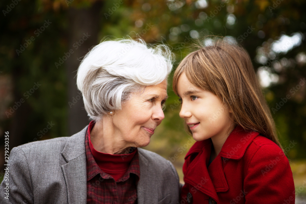 Fototapeta premium Grandmother with granddaughter (8-9) in park