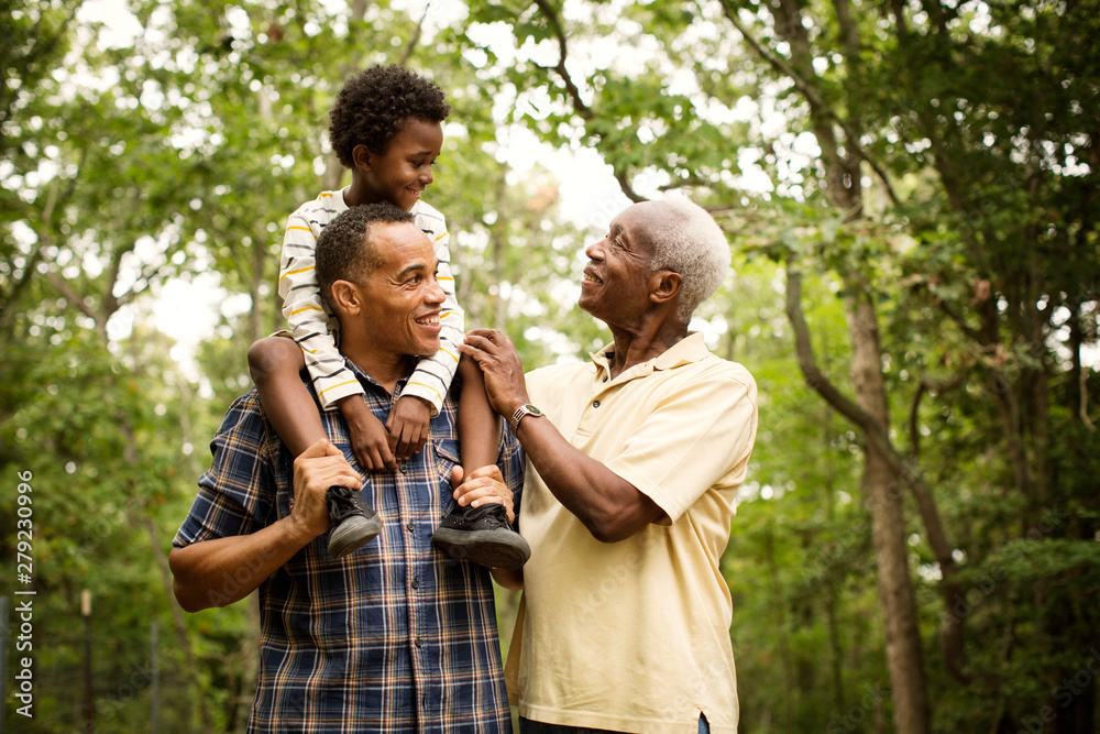 Obraz premium Smiling multigenerational family standing in forest