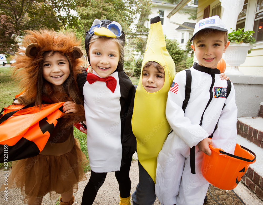 Fototapeta premium Portrait of smiling friends in Halloween costume standing outdoors