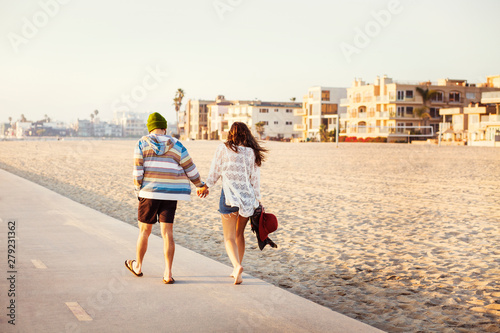 Slika na platnu Young couple holding hands city in background