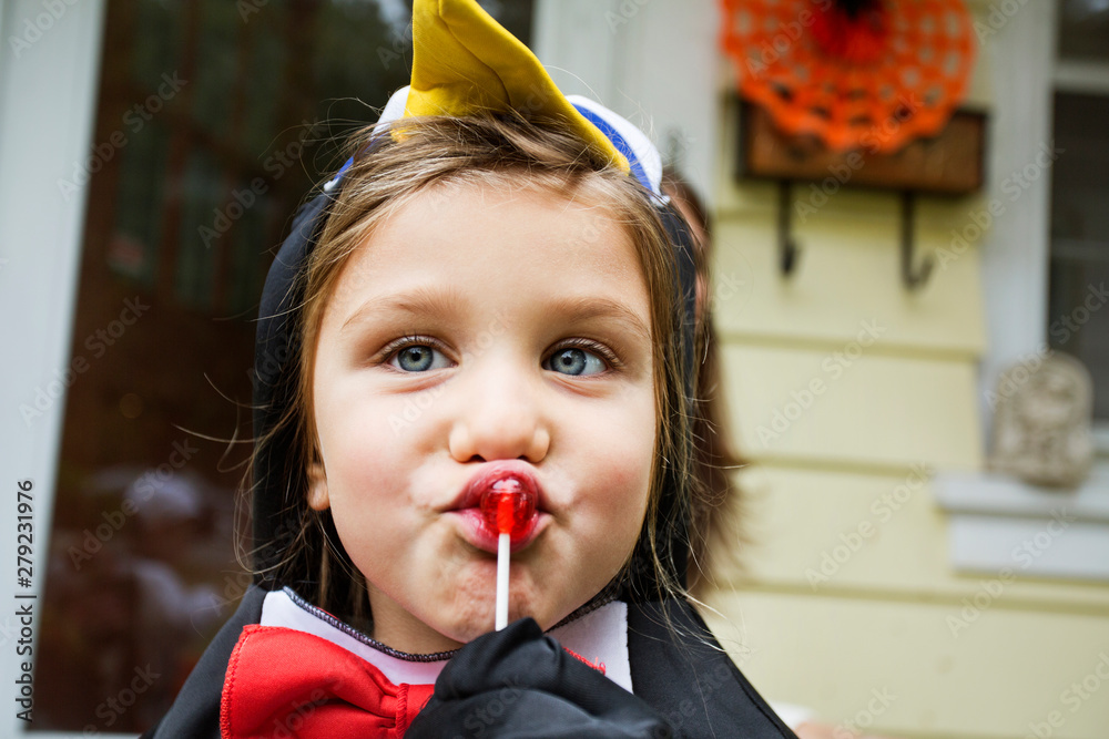 Obraz premium Close up of girl in costume eating lollipop
