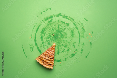 One slice of apple pie on green background