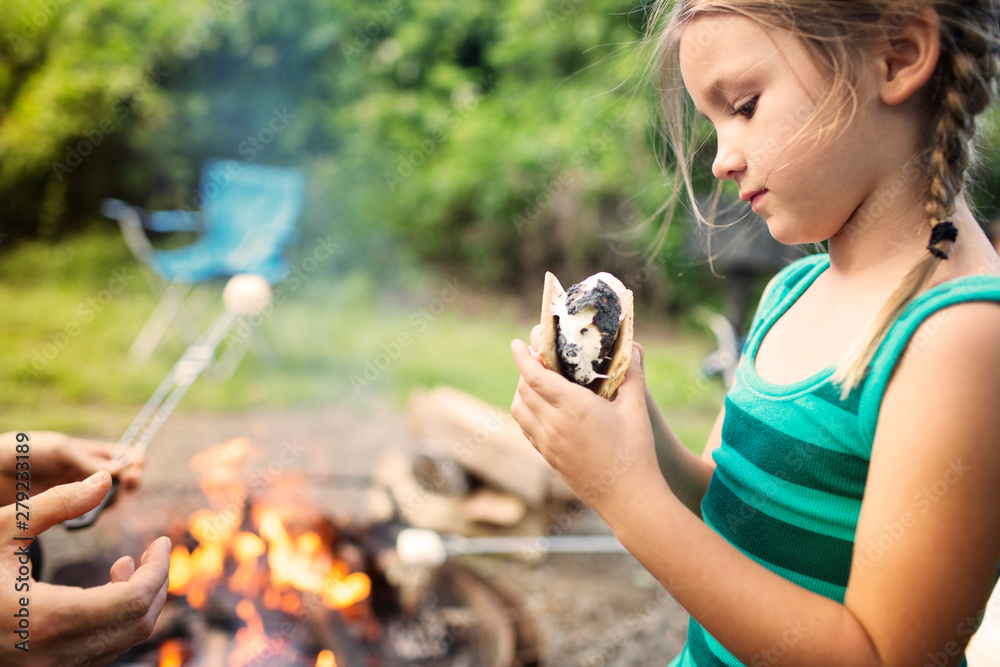 Obraz premium Girl having s'more by campfire