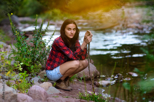 Εκτύπωση καμβά Young woman crouching on riverbank