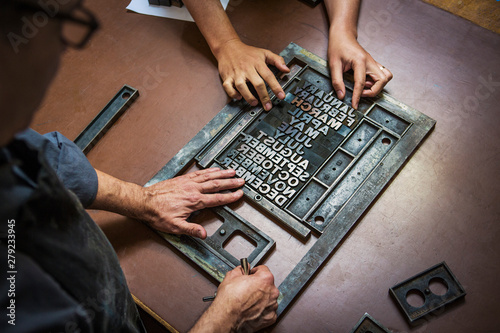 Craftsmen working with letterpress in workshop