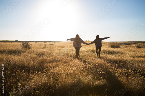 Foto Female friends walking in meadow