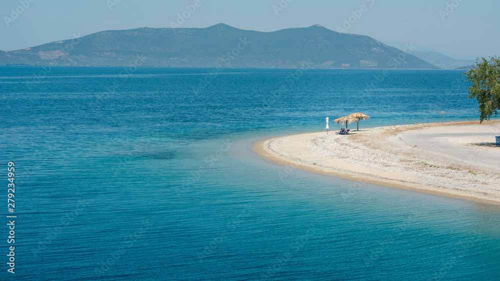 Empty beach in Greece with one sunshade