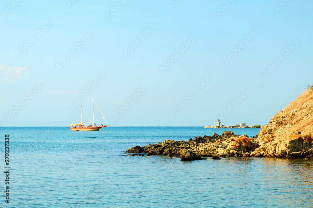 beautiful seascape with a yacht in the bay, calm sea on a windless sunny summer day