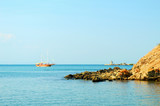 beautiful seascape with a yacht in the bay, calm sea on a windless sunny summer day