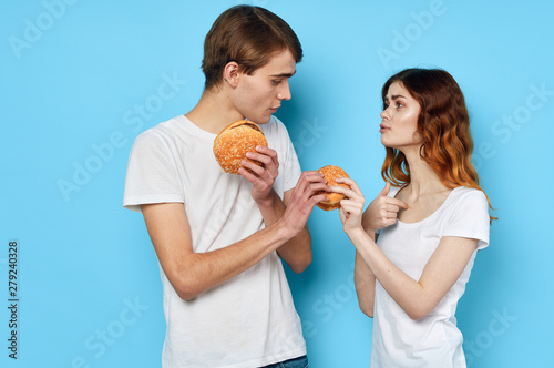 man and woman eat hamburger