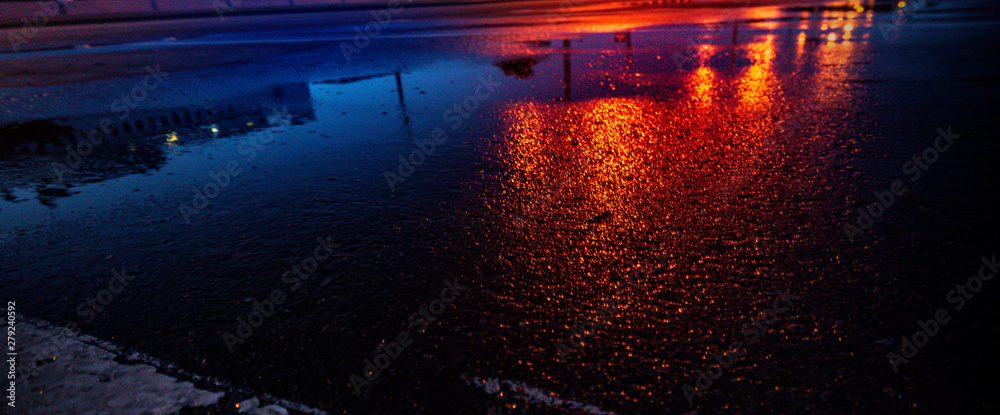 Background of wet asphalt with neon light. Blurred background, night lights, reflection. Night city, dark street.