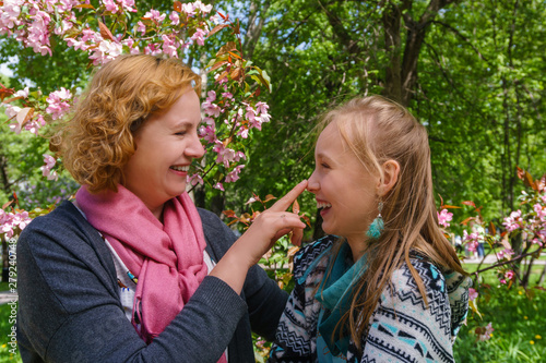 mother and daughter are talking and laughing in the park photo