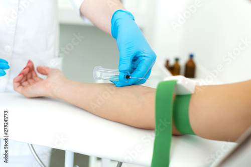 a nurse in the clinic inserts a catheter into a vein for blood testing for a young girl