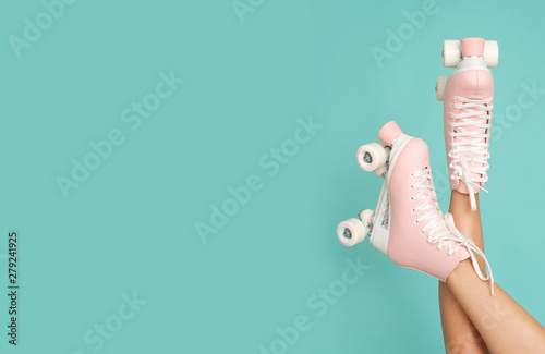 Legs up! Roller skates on slim leg isolated on the colorful background.