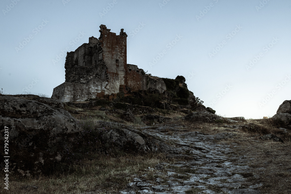 ruined castle at the top of the hill in a sunset