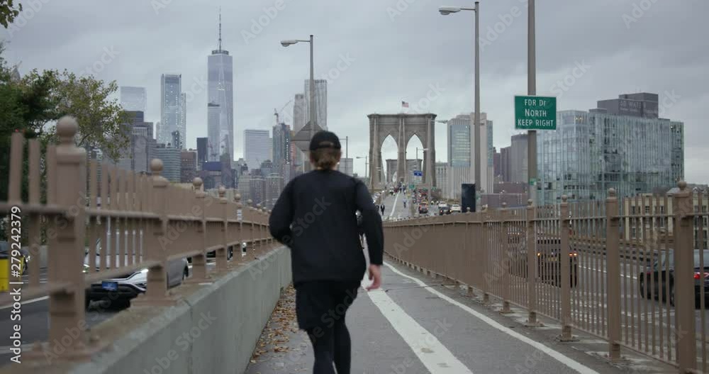 Man Running On Classic New York Road Towards Brooklyn Bridge And Impressive Skyscrapers In Beautiful NYC with Autumn Trees Man Running On Classic New York Road Towards Brooklyn Bridge And Impressive Skyscrapers In Beautiful NYC with Autumn Trees
