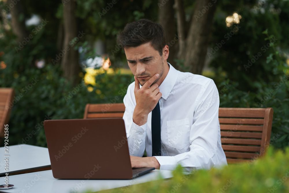 businessman working on his laptop in park businessman working on his laptop in park