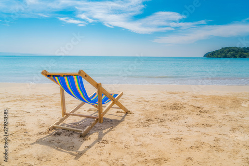 One beach chairs on the white sand with blue sky and summer sea background. Summer, Vacation, Travel and Holiday concept.