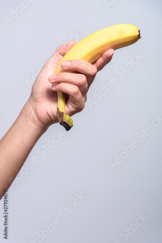 A young fitness girl holding a banana in her hand