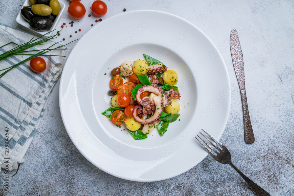 salad with vegetables and octopus on white plate salad with vegetables and octopus on white plate