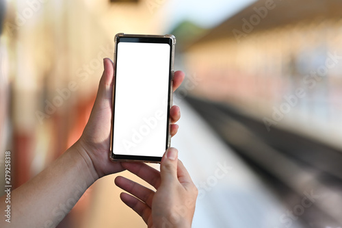 Man's Hands holding mockup smartphone with outdoor perspective.