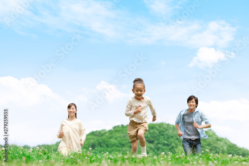野原を走る家族3人