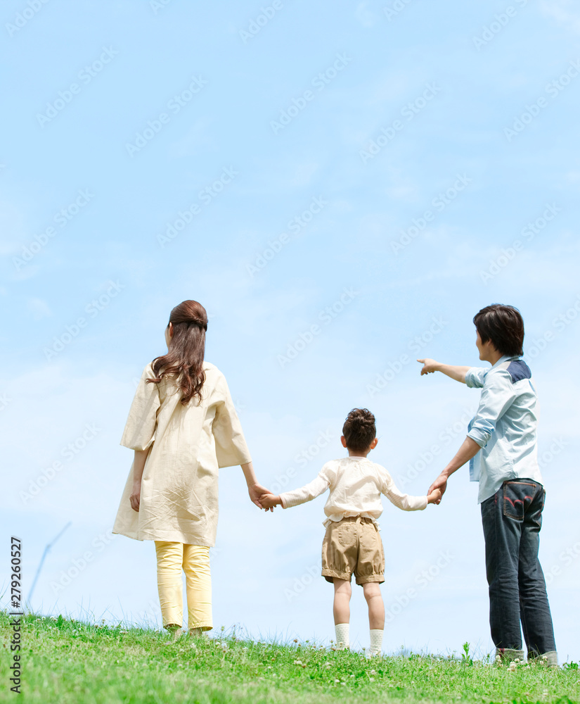 手をつなぐ家族3人の後姿