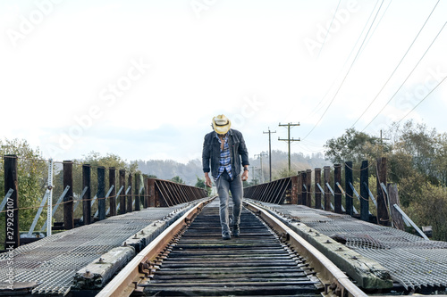 Cowboy Walking on Railroad