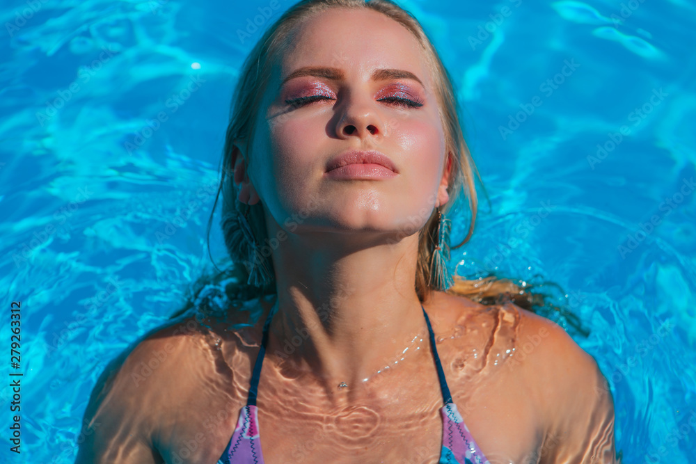 Fashion portrait of beautiful sexy young women in swimming pool