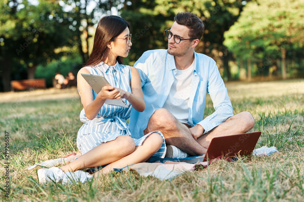 young couple sitting on bench in the park young couple sitting on bench in the park