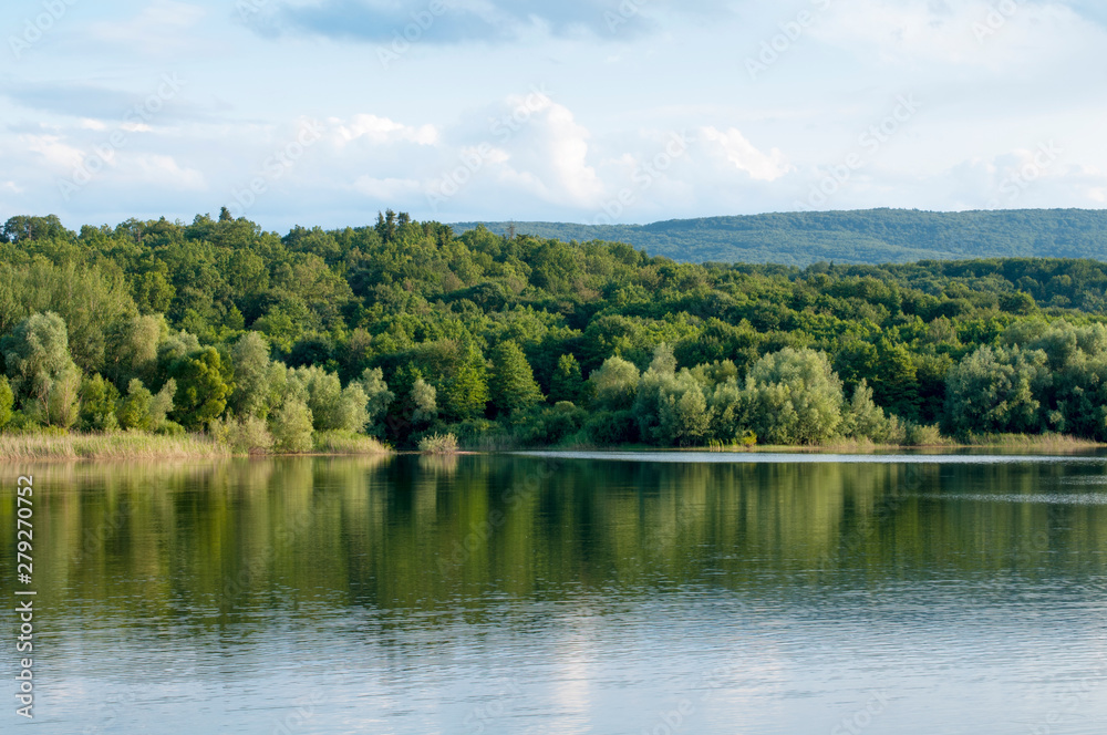 beautiful summer lake against the background of high mountains and blue sky