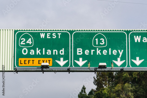 Freeway signage providing information about the lanes going to Oakland and Berkeley; San Francisco bay area, California
