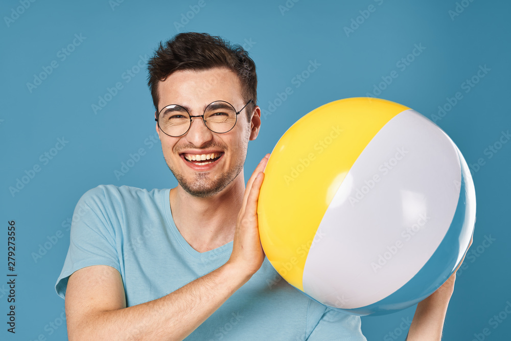 portrait of a man with ball on blue background portrait of a man with ball on blue background