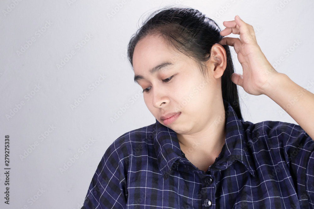 Asian young woman has itchy on her scalp isolated on grey background. Concept of scalp and hair care. Asian young woman has itchy on her scalp isolated on grey background. Concept of scalp and hair care.