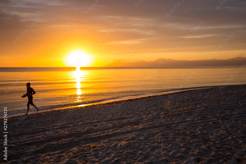 Man (Silhouette) running on Mallorca Beach during sunrise, orange