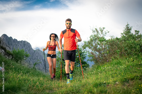 Canvas Print Sporty couple in the mountains with nordic walking poles