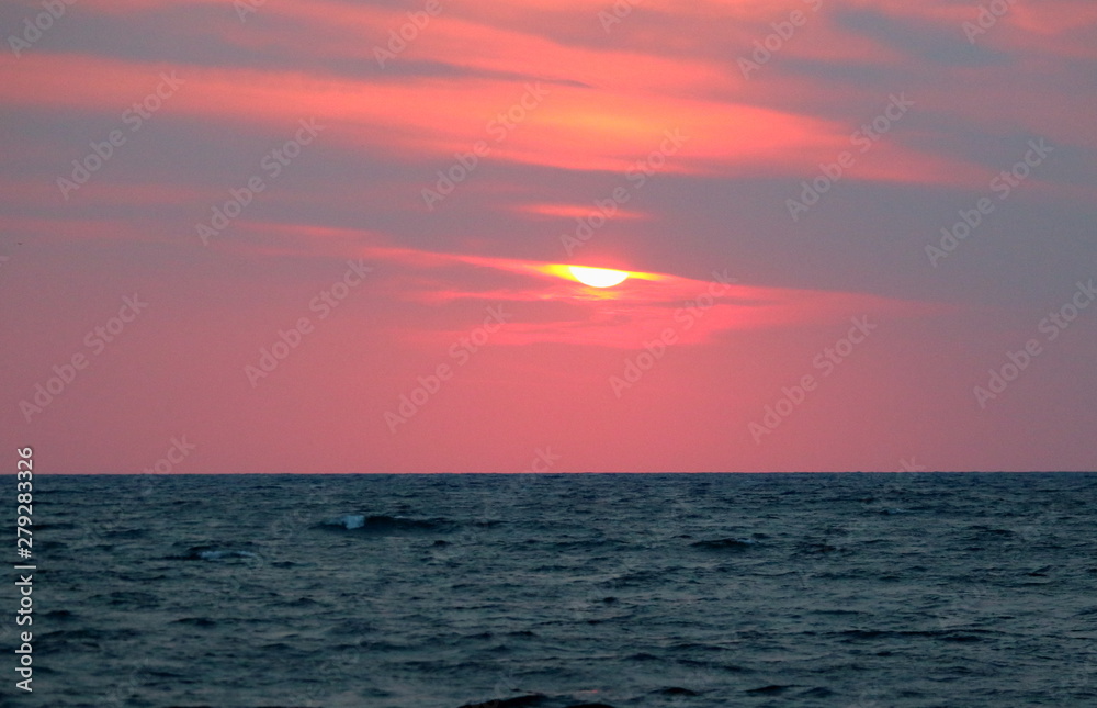 Obraz premium evocative immagine of sunset over the sea with red sun