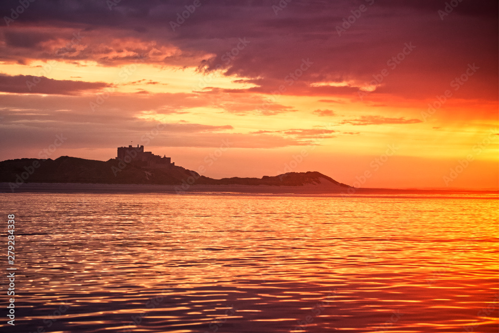 sunset over sea with castle silhouette 