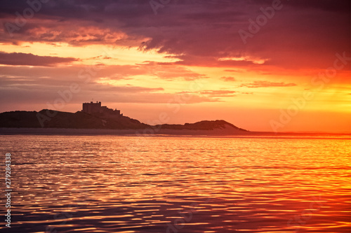 sunset over sea with castle silhouette 