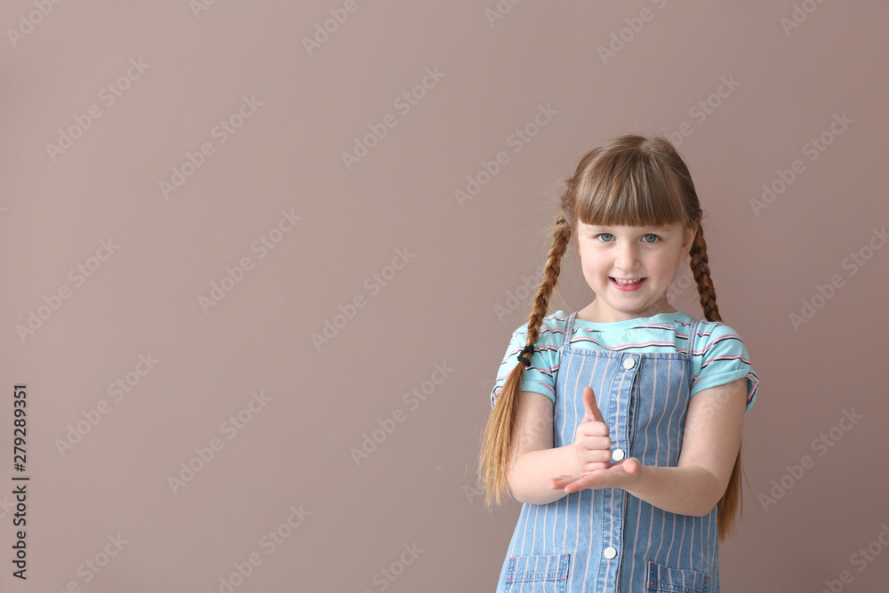 Cute deaf mute girl using sign language on color background Cute deaf mute girl using sign language on color background
