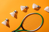 top view of shuttlecocks near badminton racket on yellow