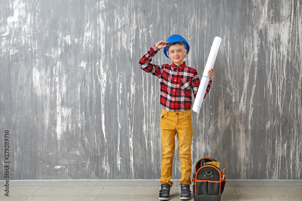 Cute little architect near grunge wall