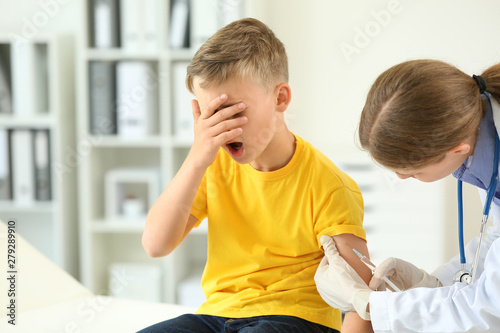 Doctor vaccinating little b...