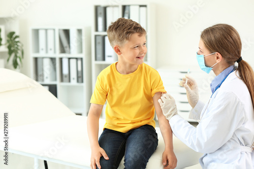 Doctor vaccinating little b...