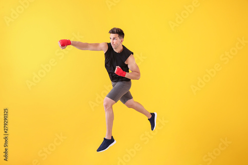 Sporty male kickboxer on color background