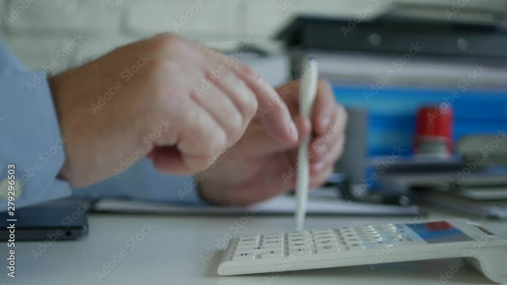 Businessman in Accounting Office Make Calculations Using Adding Machine Businessman in Accounting Office Make Calculations Using Adding Machine
