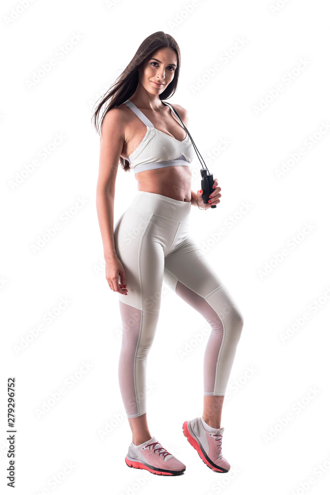 Confident attractive athletic woman fitness model posing with jump rope. Full body isolated on white background. Confident attractive athletic woman fitness model posing with jump rope. Full body isolated on white background.