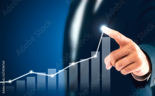 Businessman showing business growth on a chart, hands touch the graph that represents profit rises on a lot more.