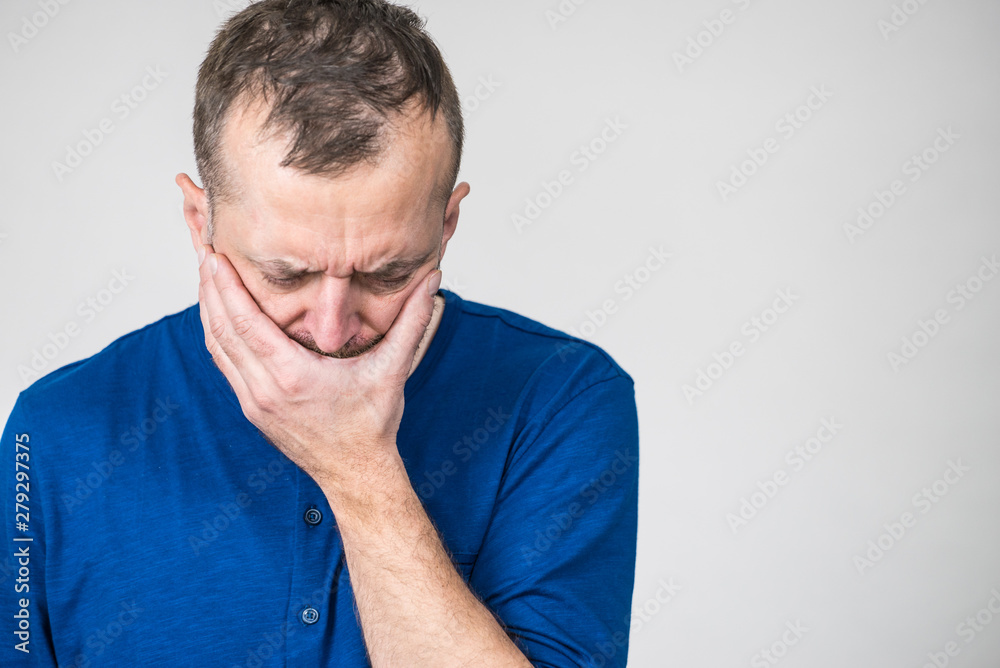 Sad worried man covering his mouth Sad worried man covering his mouth